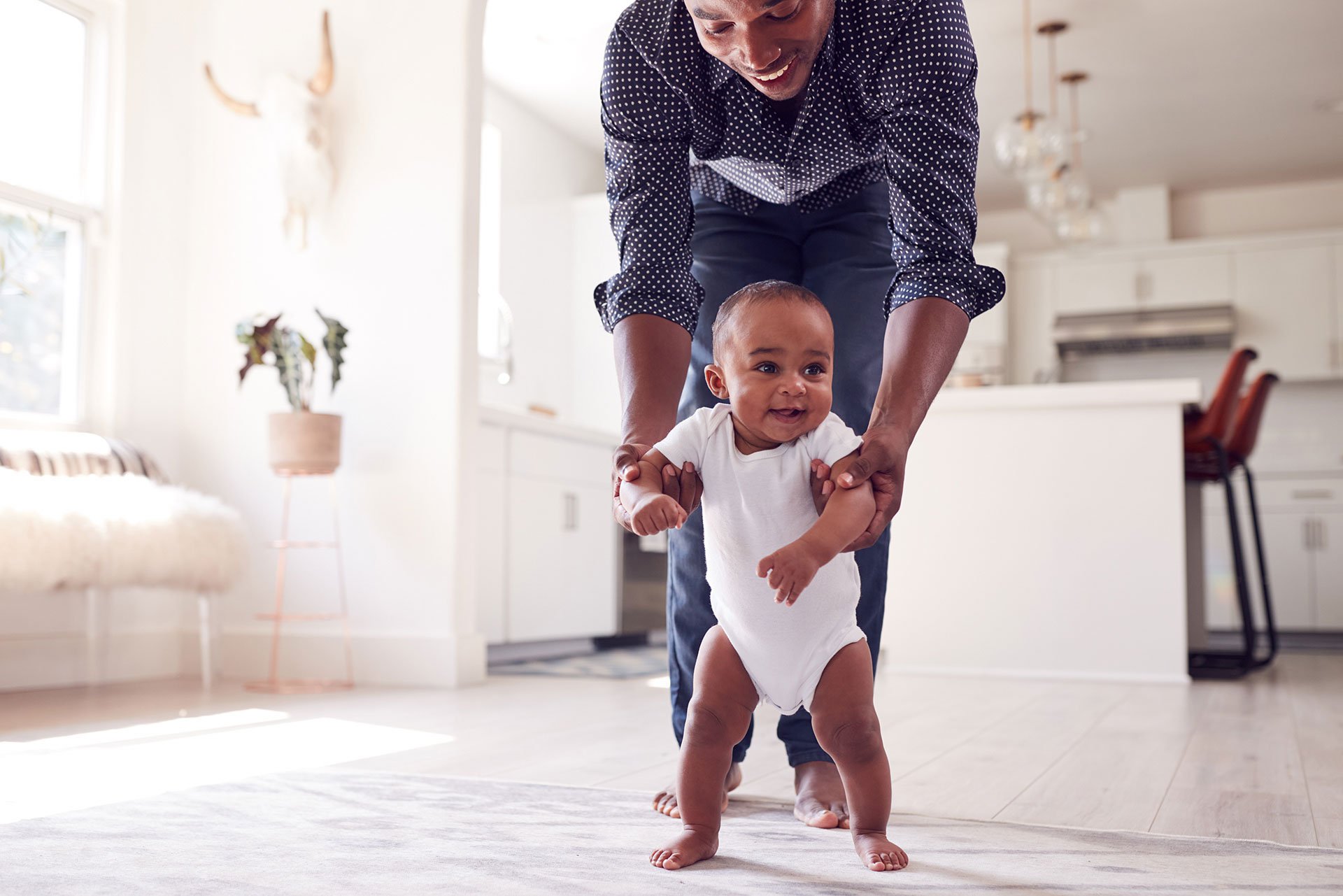 Papá enseñando a su bebé a caminar