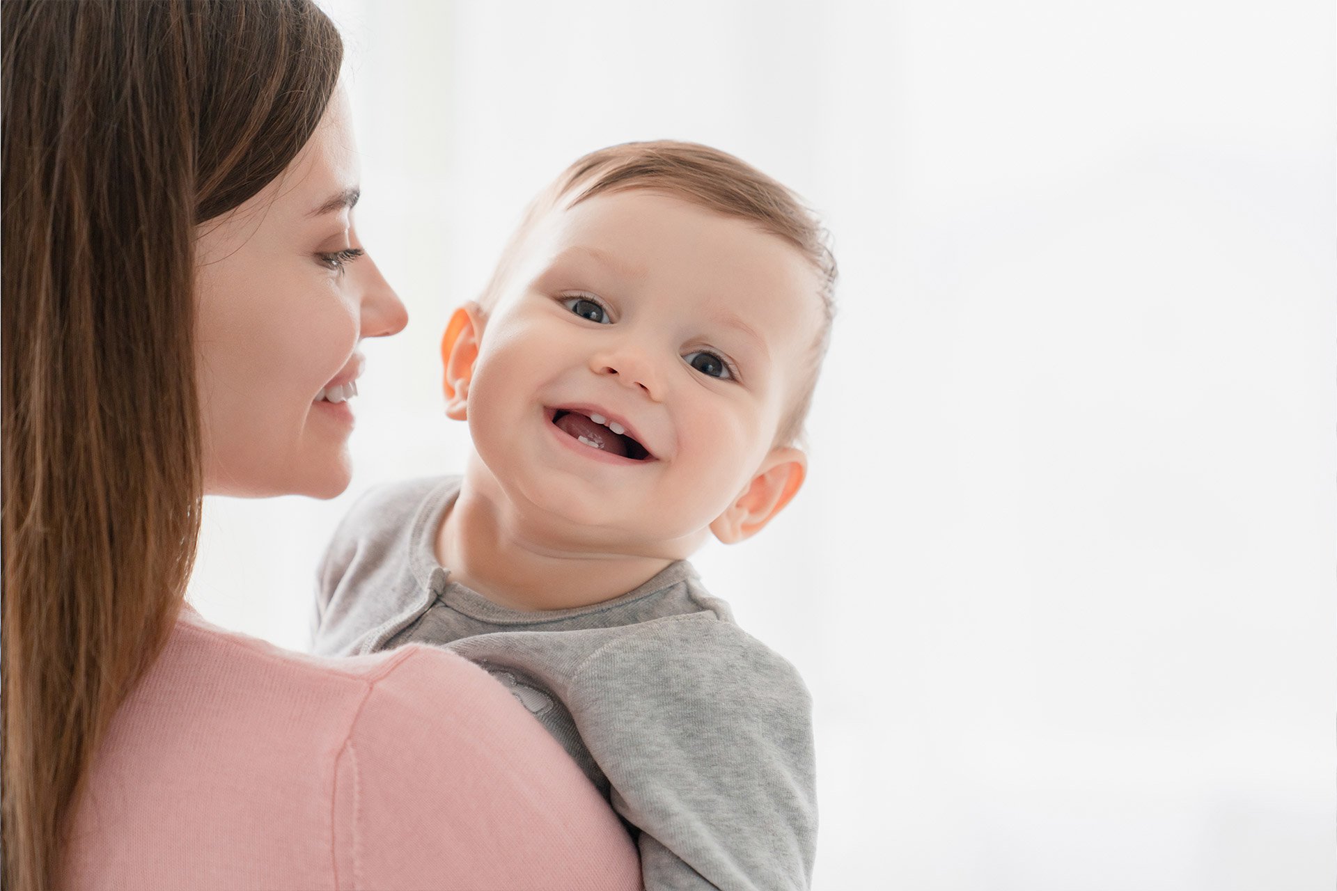 Mamá cargando a su bebé sonriendo
