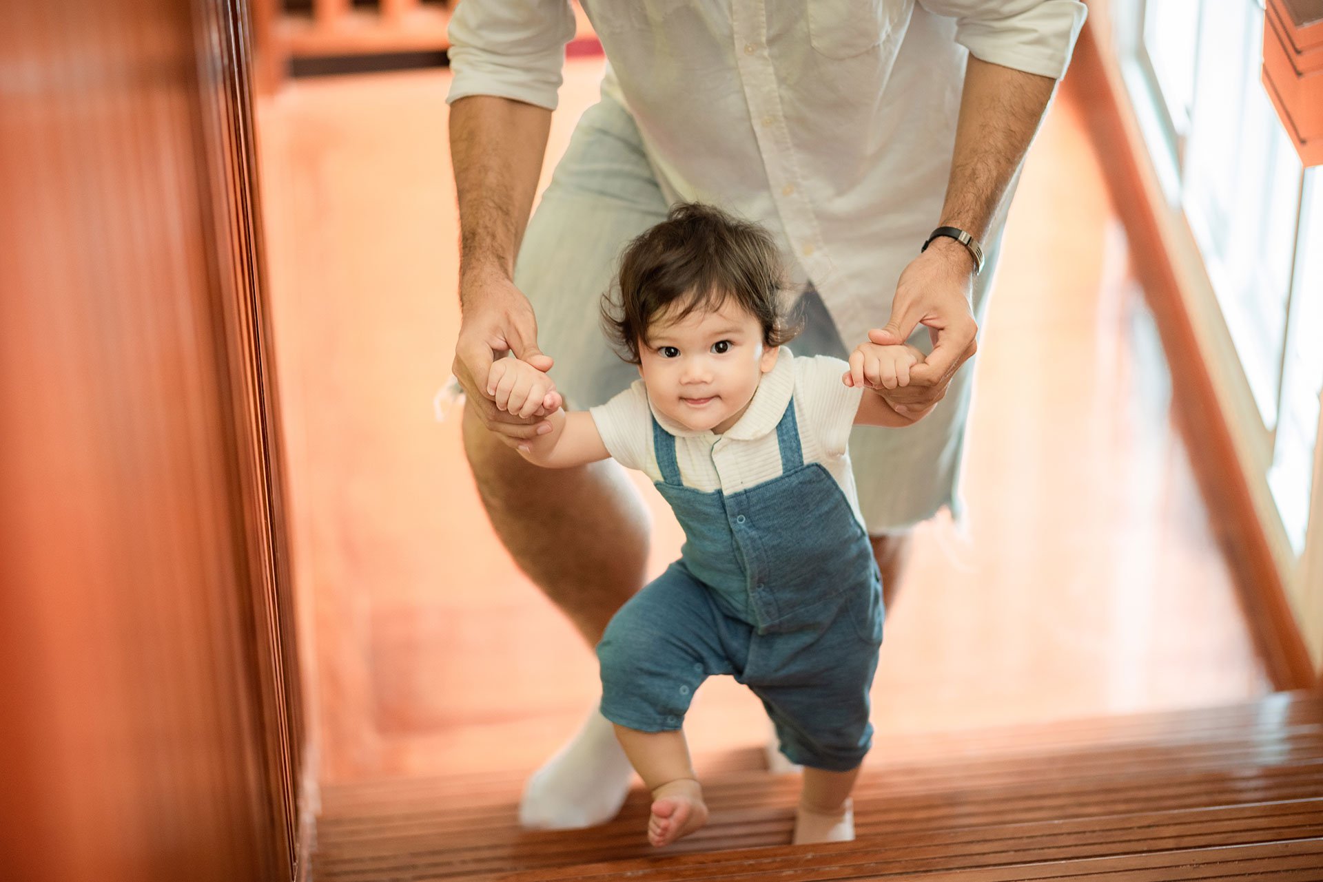 Bebé aprendiendo a caminar con su papá