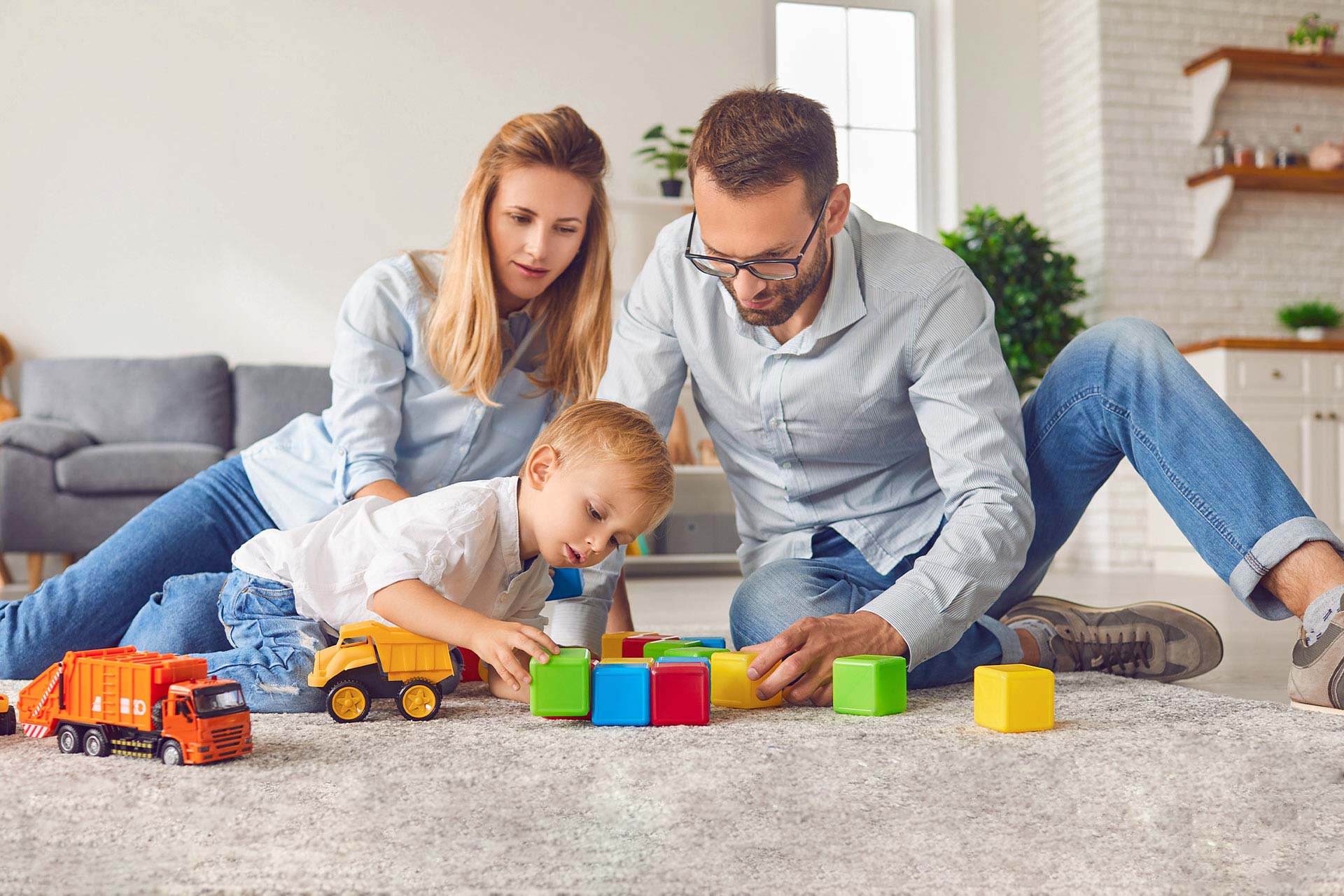 Papás jugando con su bebé en el piso