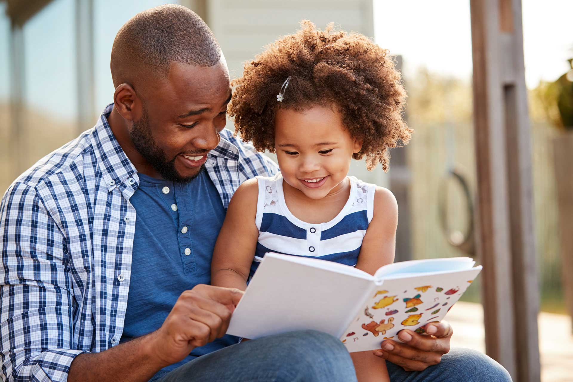 Papá leyendo con su hija pequeña