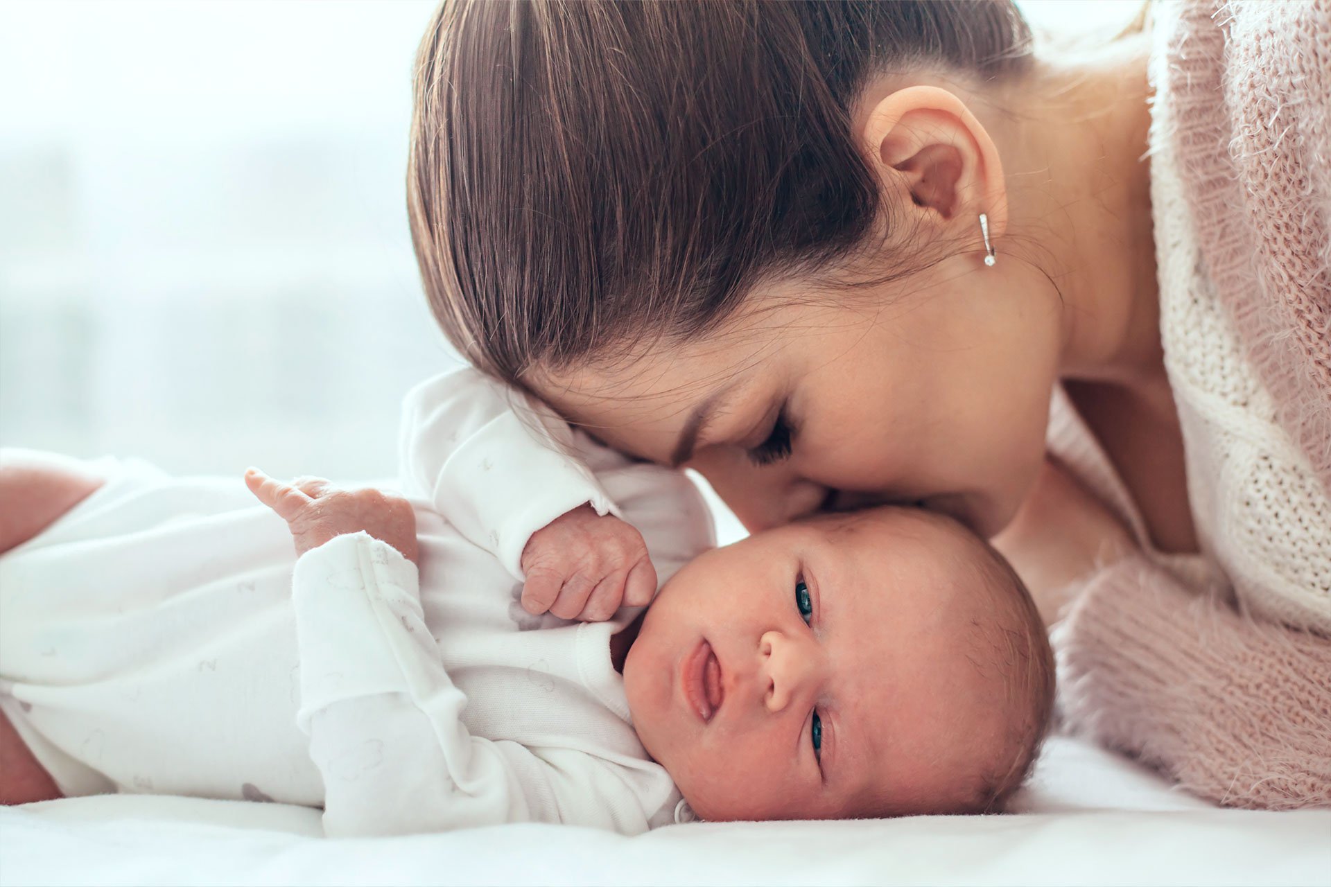Mamá dándole un beso a su bebé en la cabeza