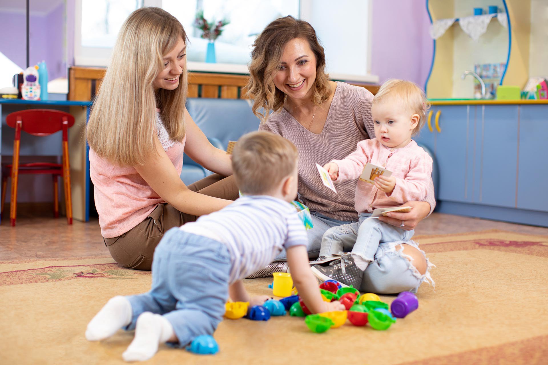 Dos bebés conociéndose con sus mamás