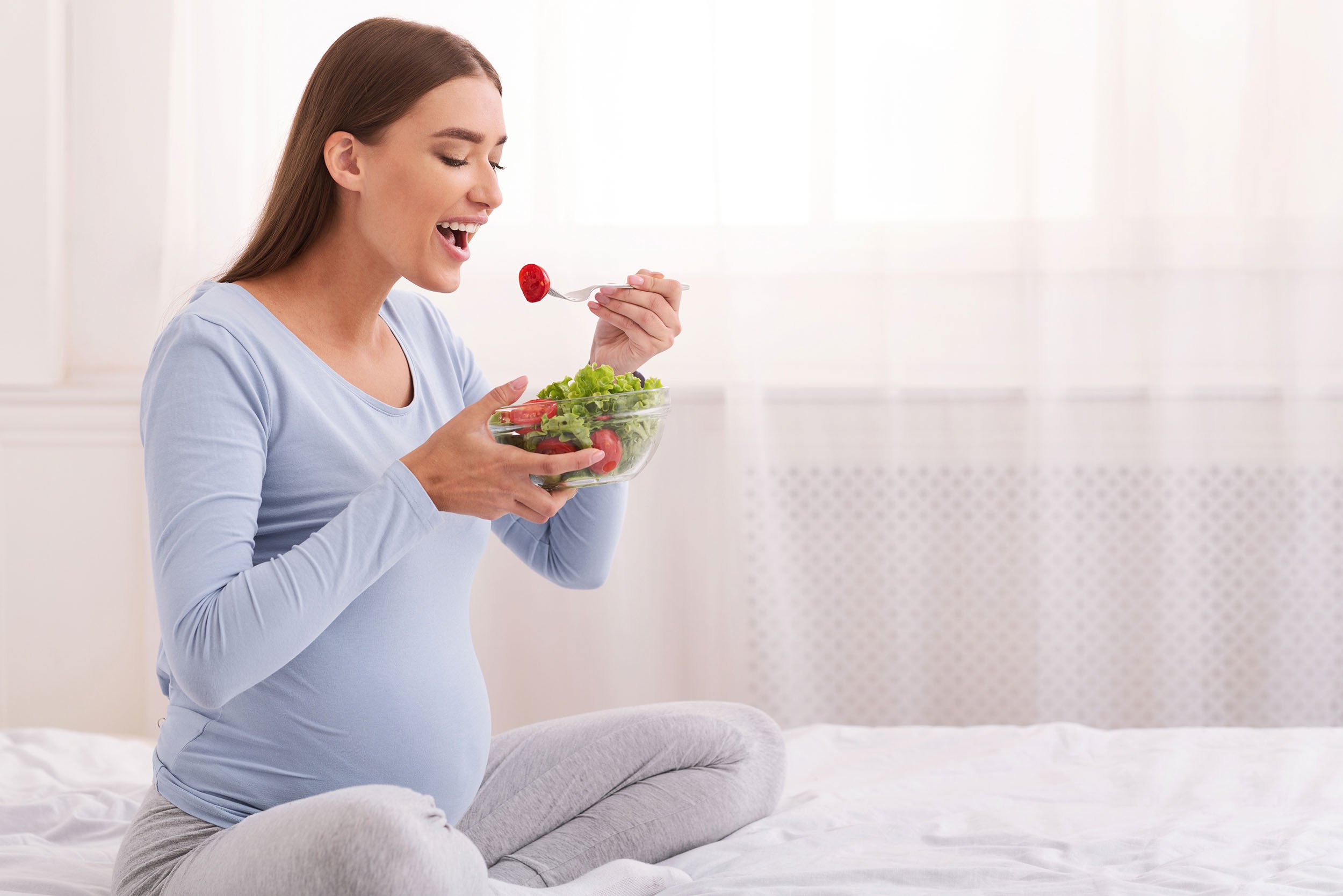 Embarazada comiendo ensalada