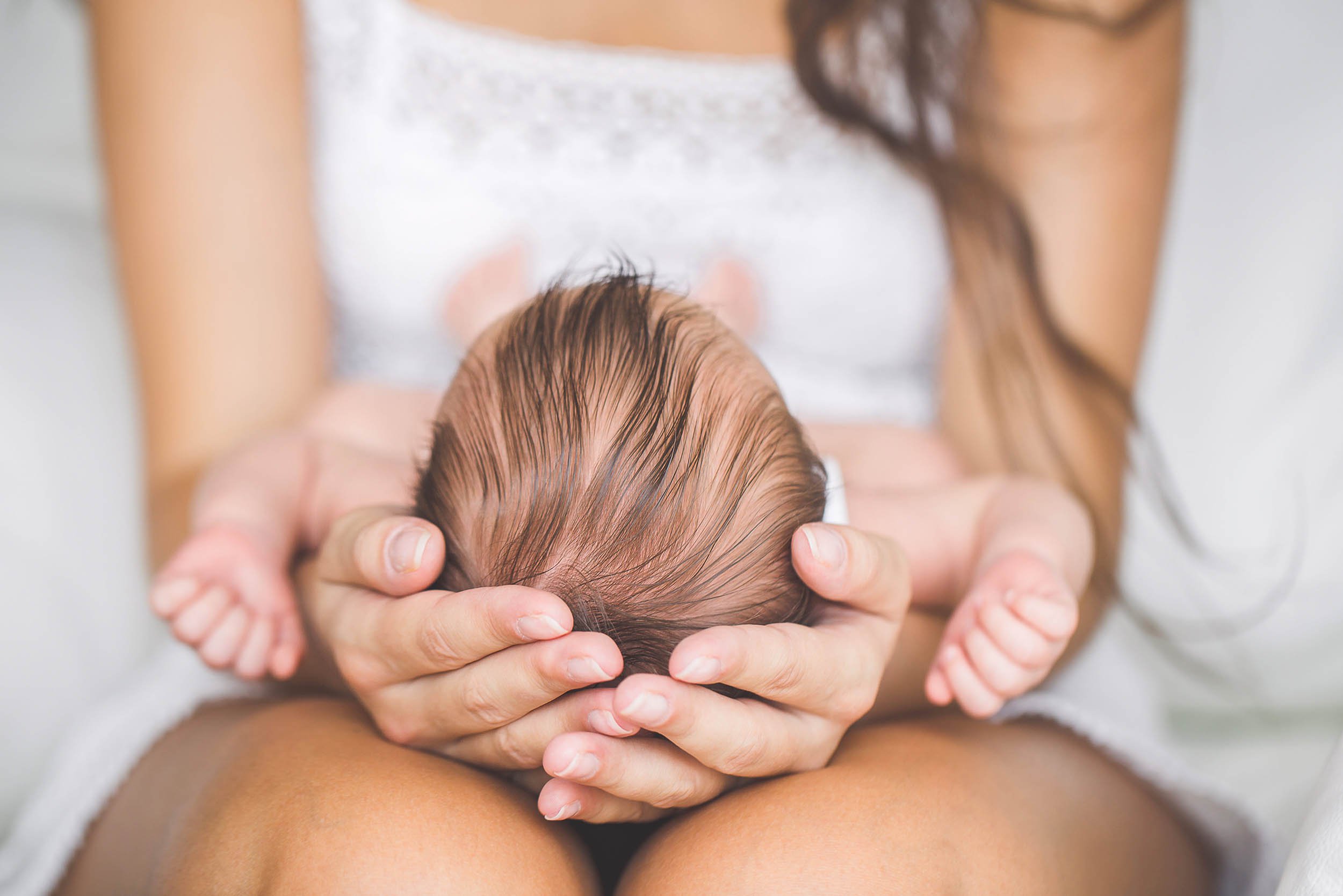 Mamá cargando a  su bebé en las piernas