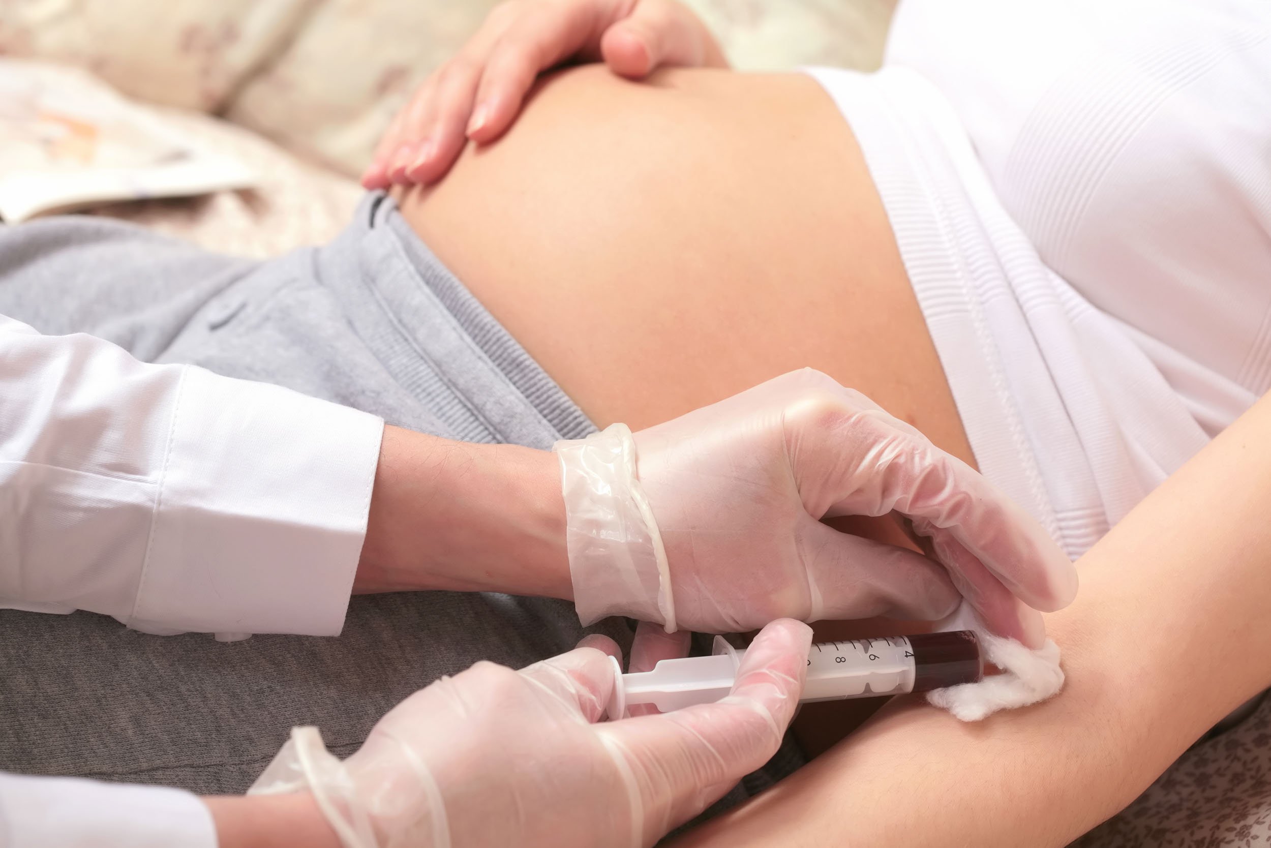 Enfermera sacando prueba de sangre a embarazada