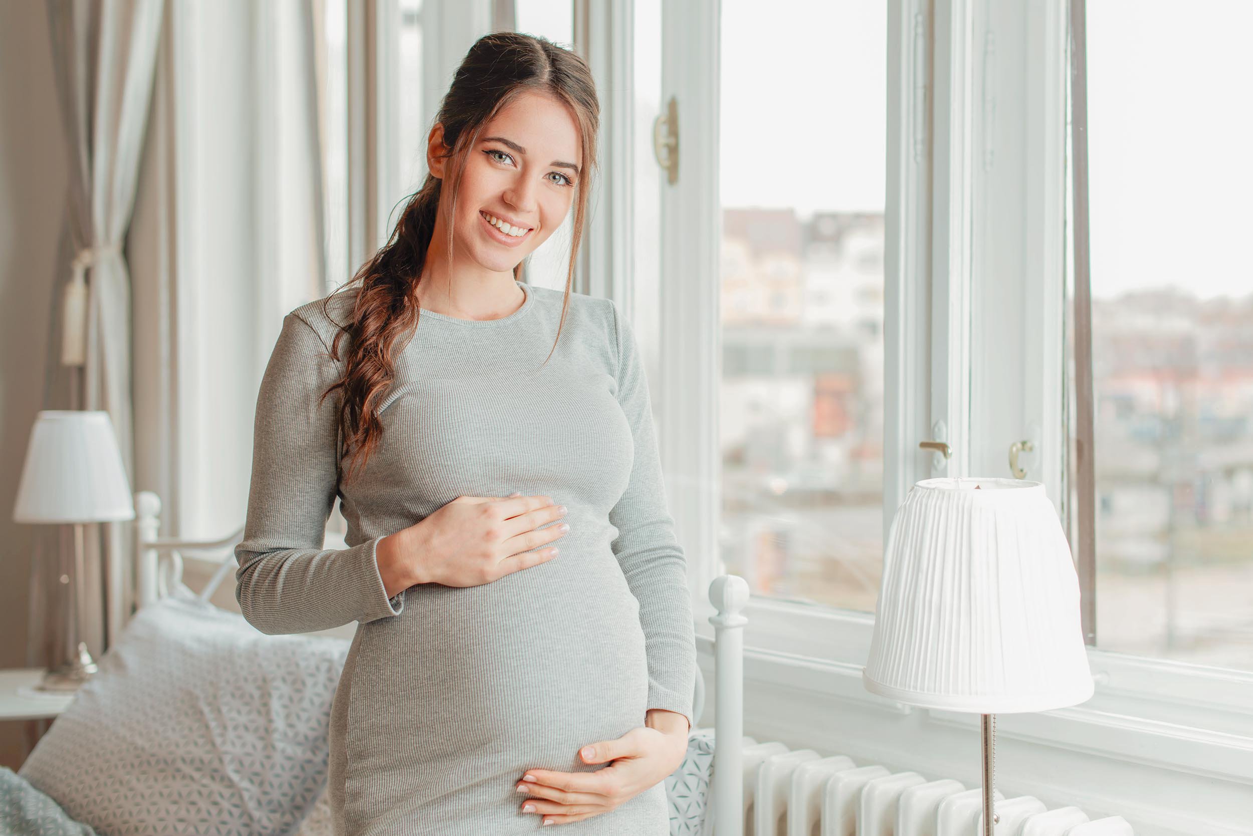 Embarazada sonriendo acariciando su barriga