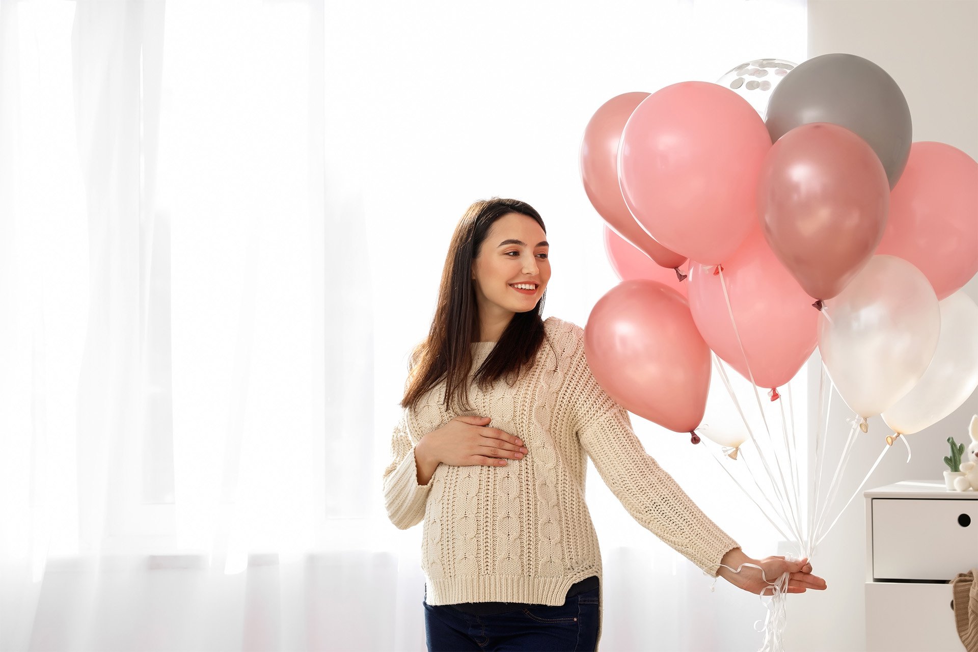 Mamá embarazada con globos en su mano