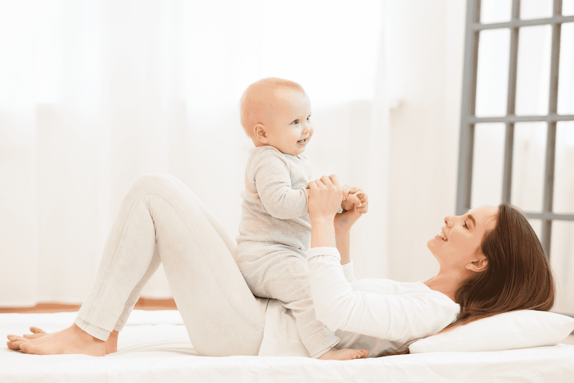 Mamá acostada cargando a su hijo en el pecho.