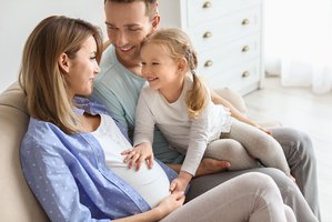 Familia tocando la barriga de mamá embarazada