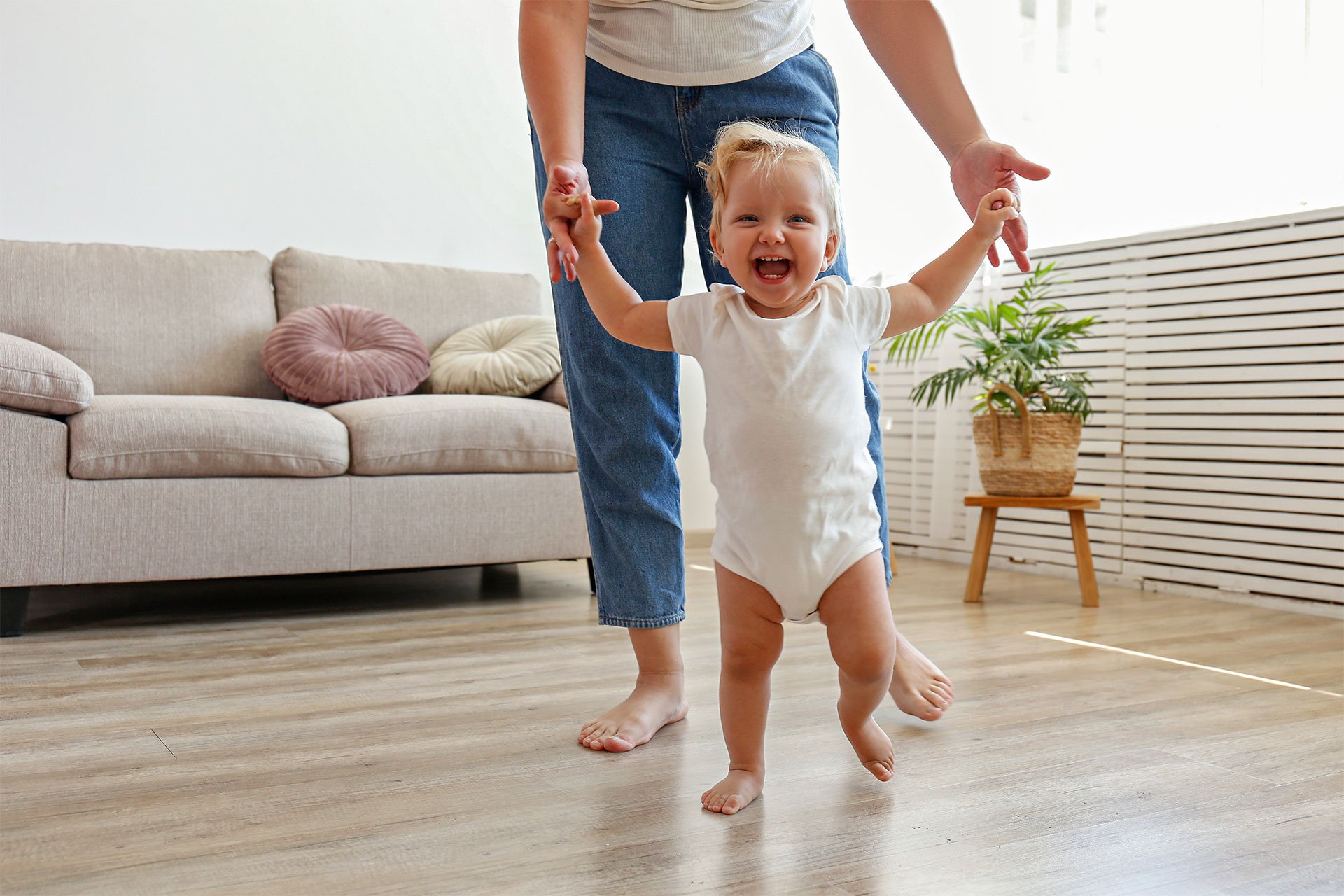 Mamá ayudando a caminar a su bebé