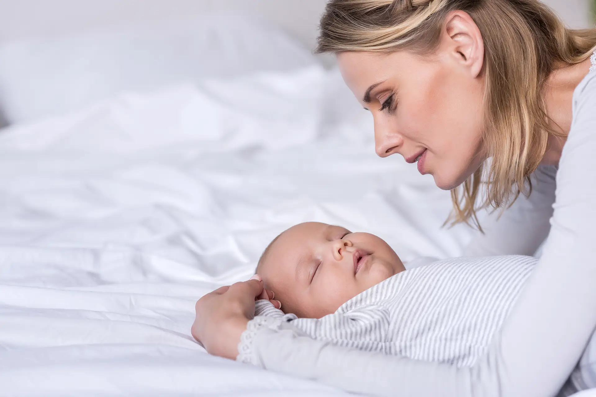 Mamá durmiendo a su bebé.