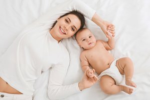 Mamá acotada en la cama son su bebé