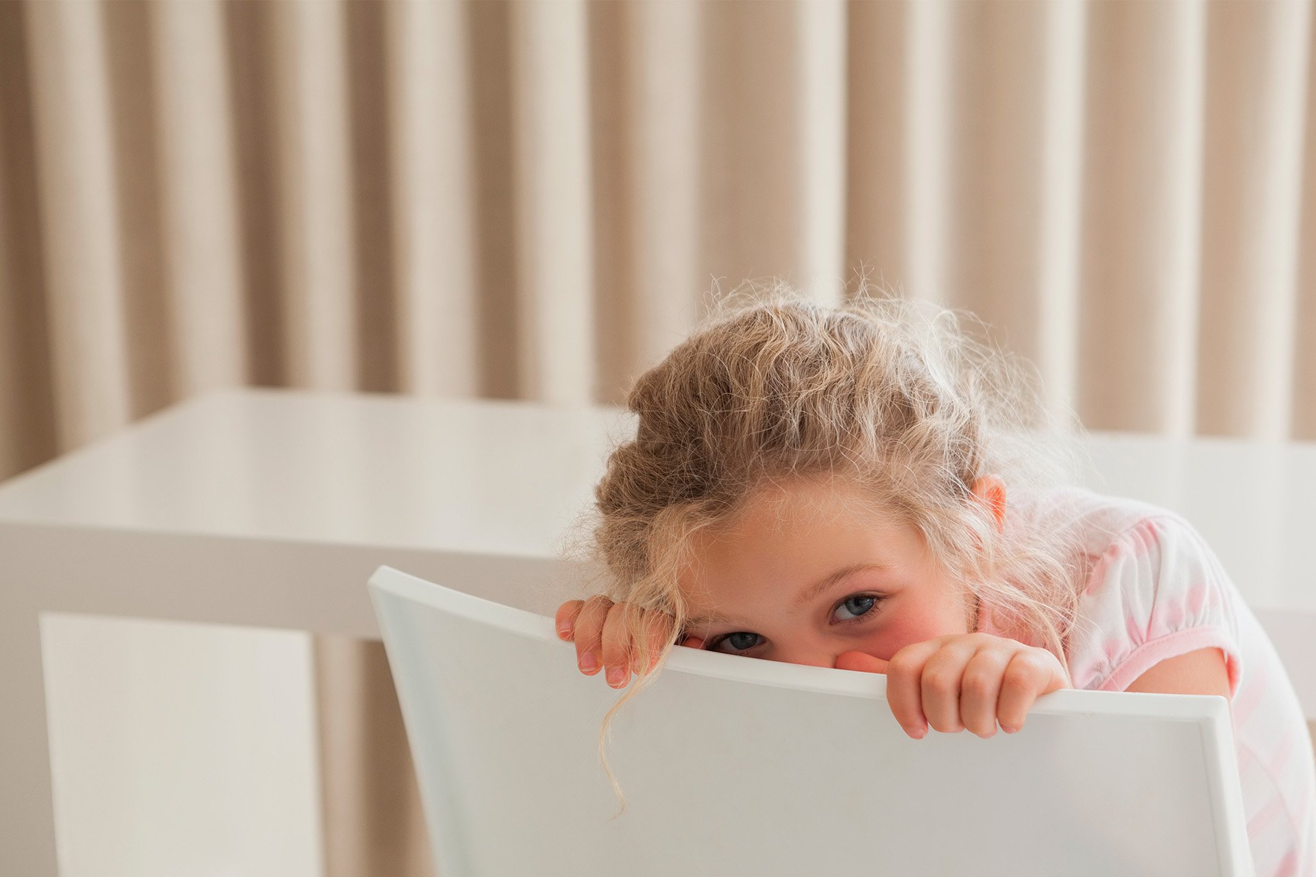 Niña ocultando su cara.