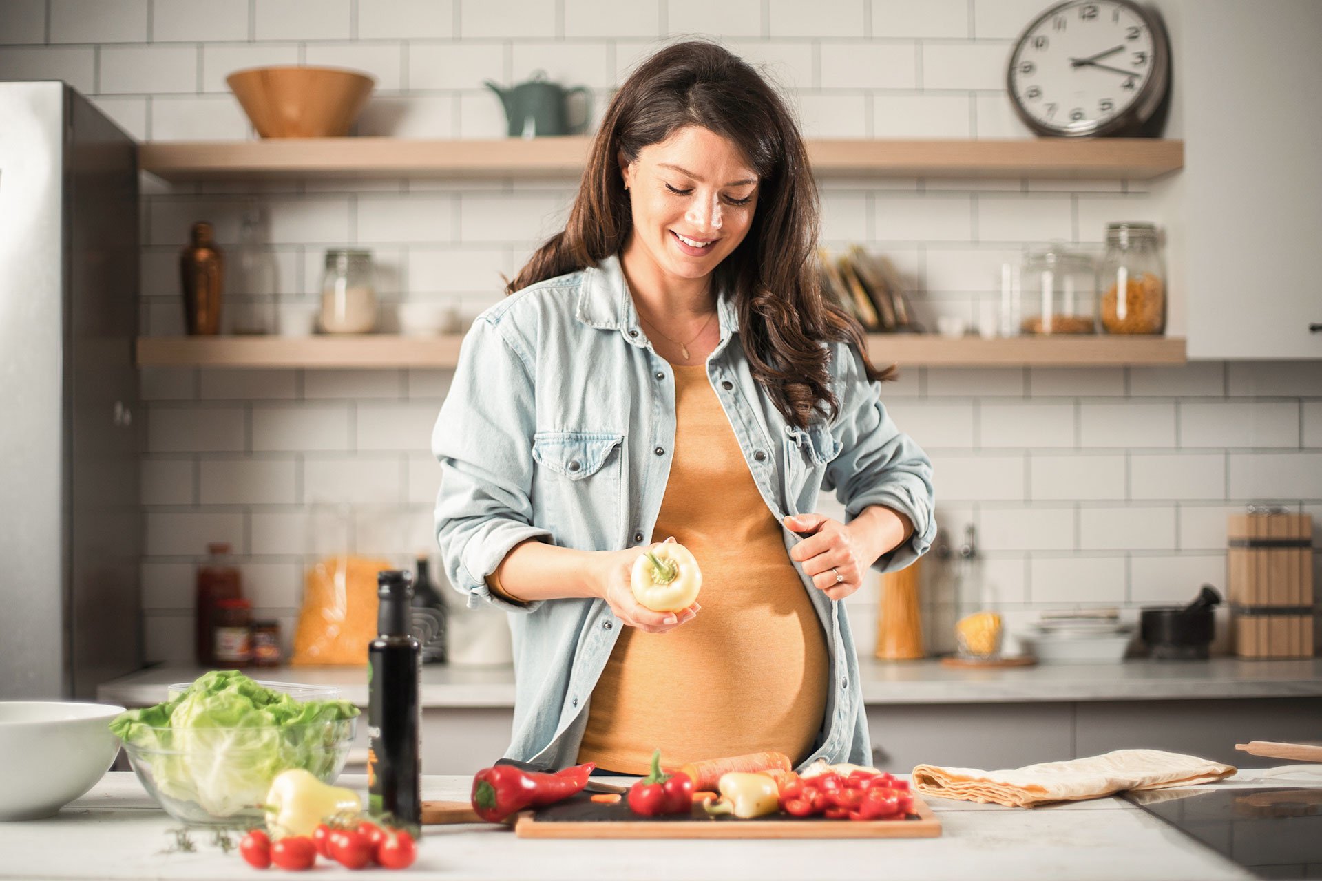 Mujer embarazada cocinando saludable
